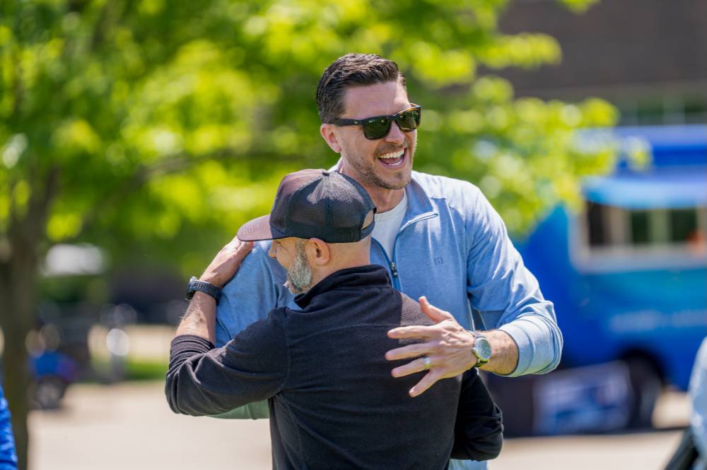 The winning teammates smile and hug after their victory